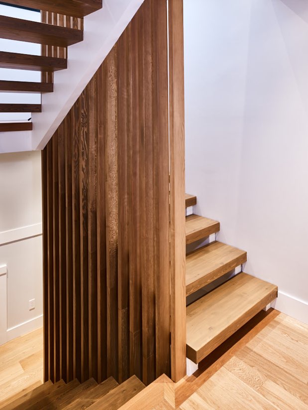 Indoor interior image showcasing custom wooden staircase with white walls. design by N B A architects.