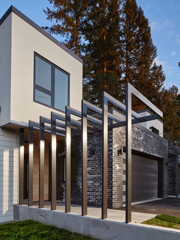 a front entrance image of the two-story duplex featuring the modern entrance canopy. N B A architects designed an ultra-modern architectural design, high-performance, innovative, and sustainable home that is constructed from prefabricated SIPs.
