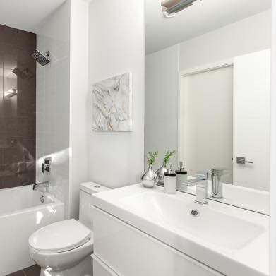 Interior image of a white bathroom with the bath with black tile wall. Designed by N B A architects.