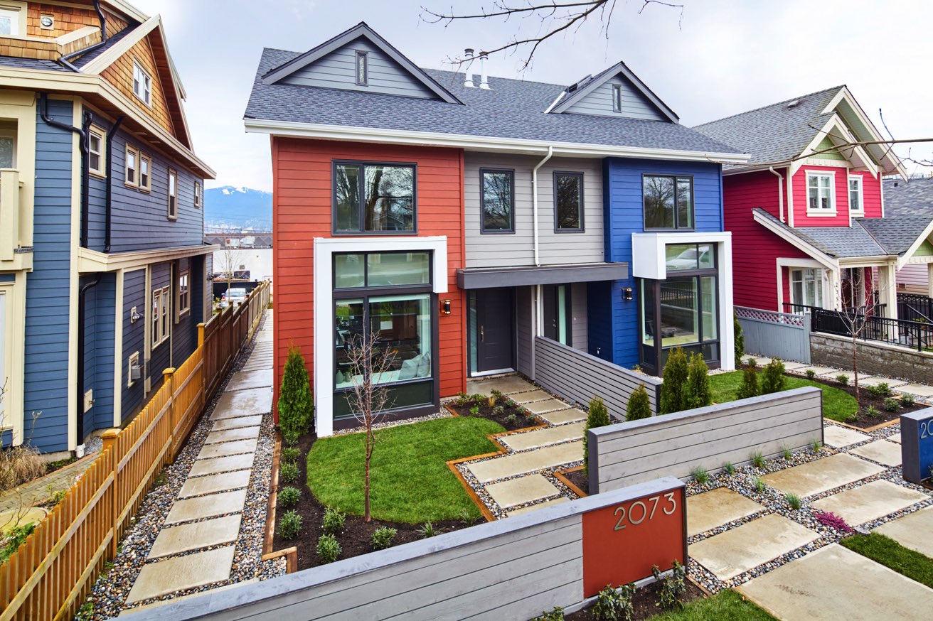 An exterior image from the front of the duplex, featuring colourful elevations and distinct entrances for several families. The Passive-House approach to design achieves lower-energy, healthier and more sustainable homes. It has been built to stand the test of time. design by N B A architects.