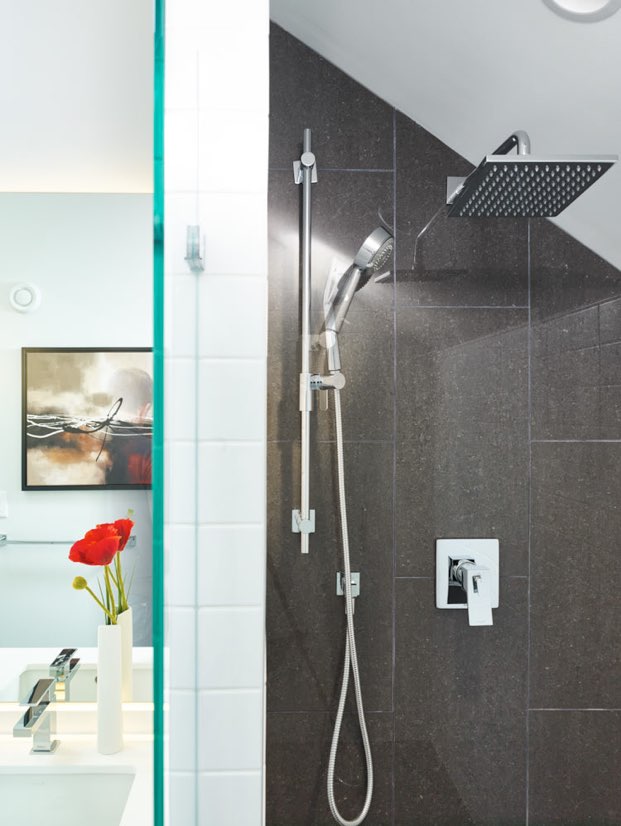 Interior image of a master bathroom shower featuring black tiles. design by N B A architects.