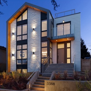 N B A designed high-performance two-story modern design House featuring high end home over 1 bedroom suite and 2-bedroom apartment. Constructed from prefabricated Structural Insulated Panels. N B A architects focused on highly innovative construction technologies regarding performance and sustainability.