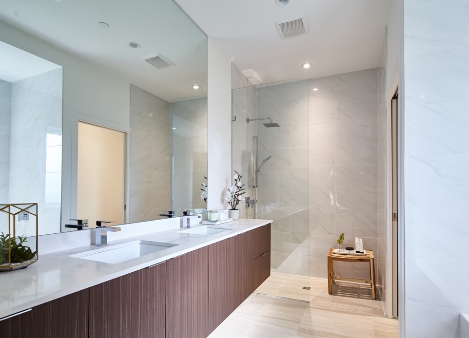 Interior image of a spacious white shower room and dark wood millwork elements featuring a double sink and high ceiling shower. White timeless design