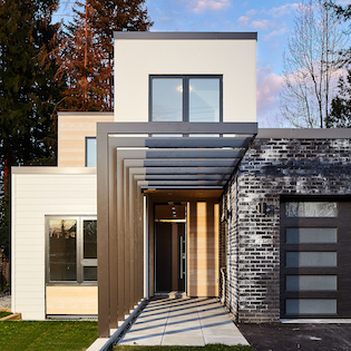 A front entrance image of the two-story duplex. N B A architects designed an ultra-modern architectural design, high-performance, innovative and sustainable home that is constructed from prefabricated SIPs.