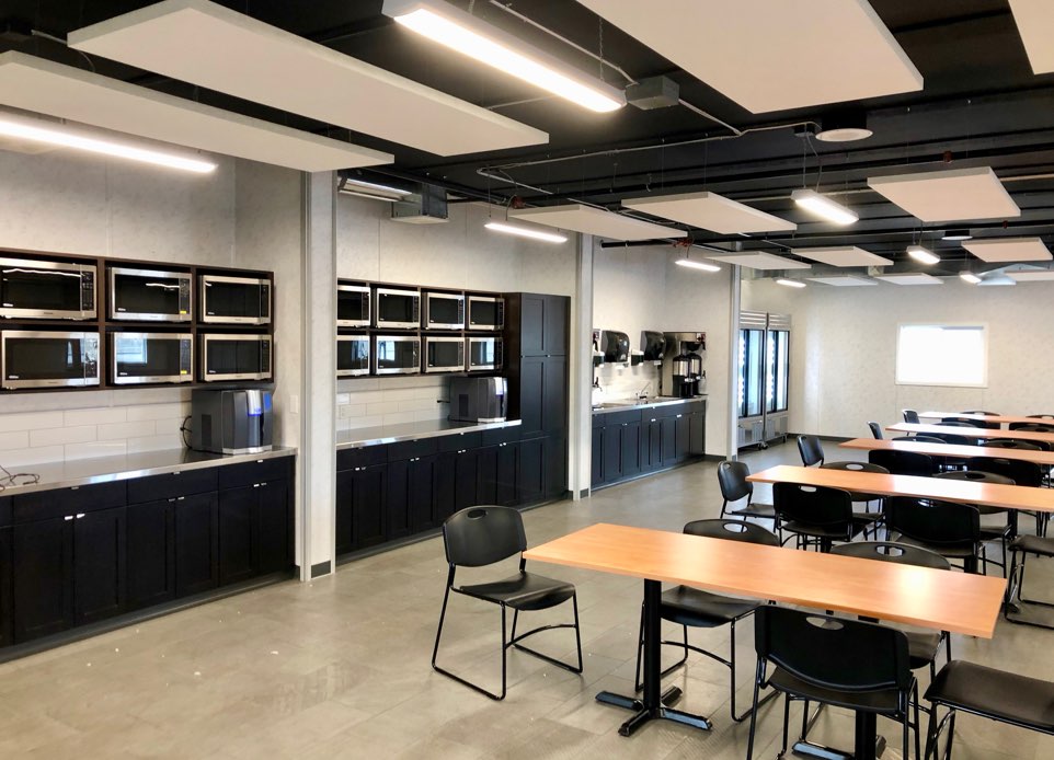 An interior image showing the training room for the staff featuring the kitchen spaces for workers on the side. Nba architects designed a staff facility building for the port workers at Deltaport. 