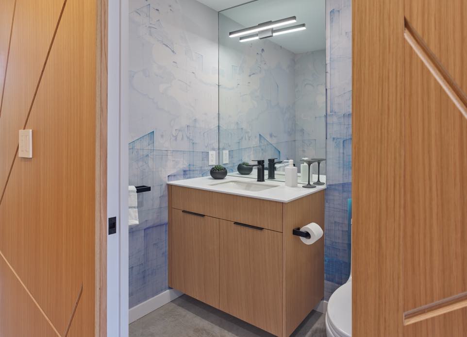 Interior image of a bathroom. Wood millwork and artistic light blue walls.
