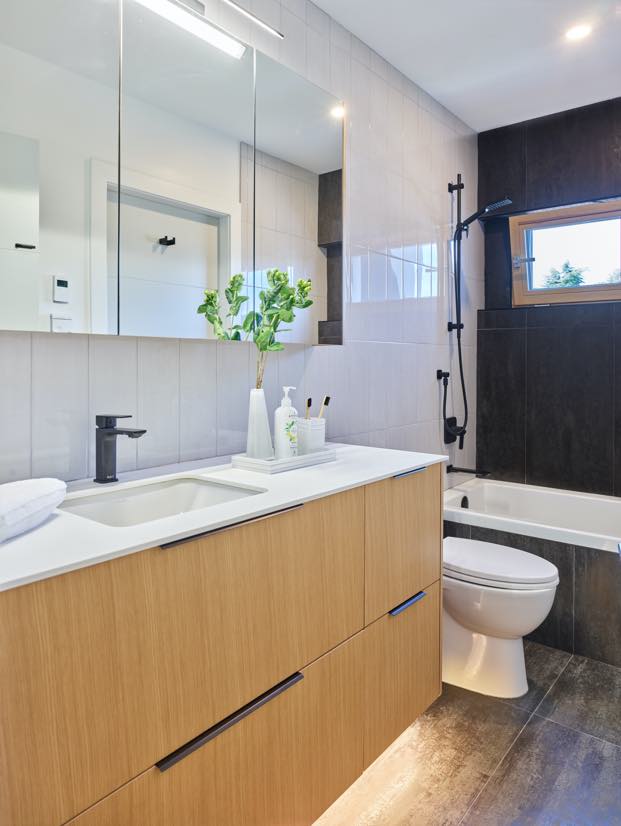 Interior image of a bathroom with the bath and white tile walls.