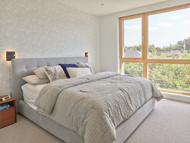 Interior image of a master bedroom featuring triple glazed window.