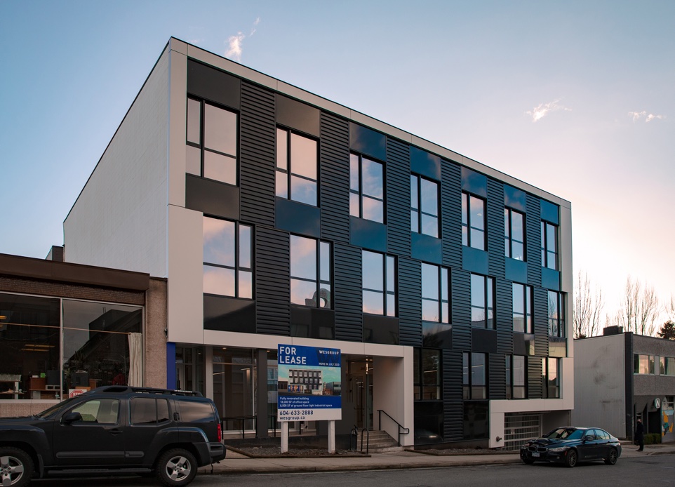 The exterior image of 3-storey mixed-use building in Mount Pleasant. Nba architects designed a 2 floors of office over light industrial commercial space, the intent is to strip out and remodel the interior, demolish the front facade and liven up the streetscape with a redesigned exterior, including three cool outdoor patio spaces. 