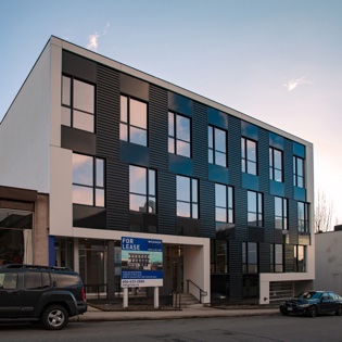 The exterior image of 3-storey mixed-use building in Mount Pleasant. Nba architects designed a 2 floors of office over light industrial commercial space, the intent is to strip out and remodel the interior, demolish the front facade and liven up the streetscape with a redesigned exterior, including three cool outdoor patio spaces.