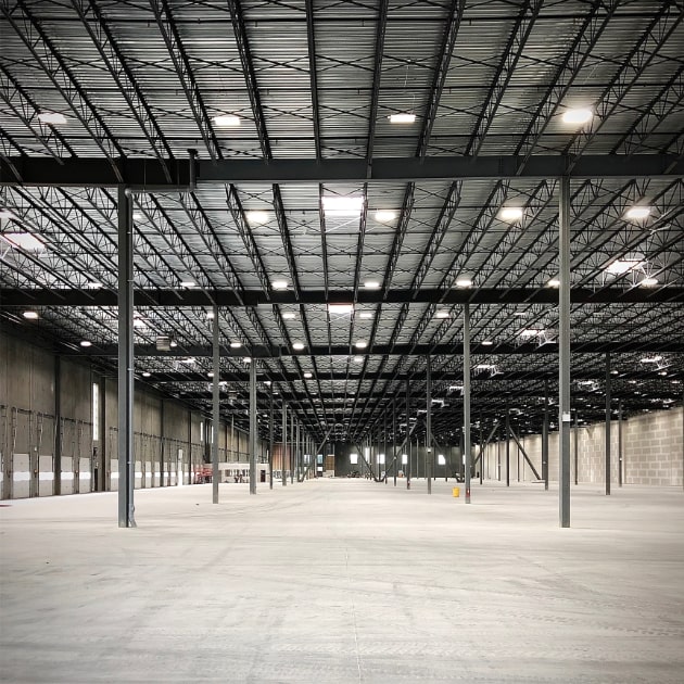 An image shows an existing building improvement to 600,000 square foot warehouse by N B A architects. This interior image shows massive interior space that was upgraded.