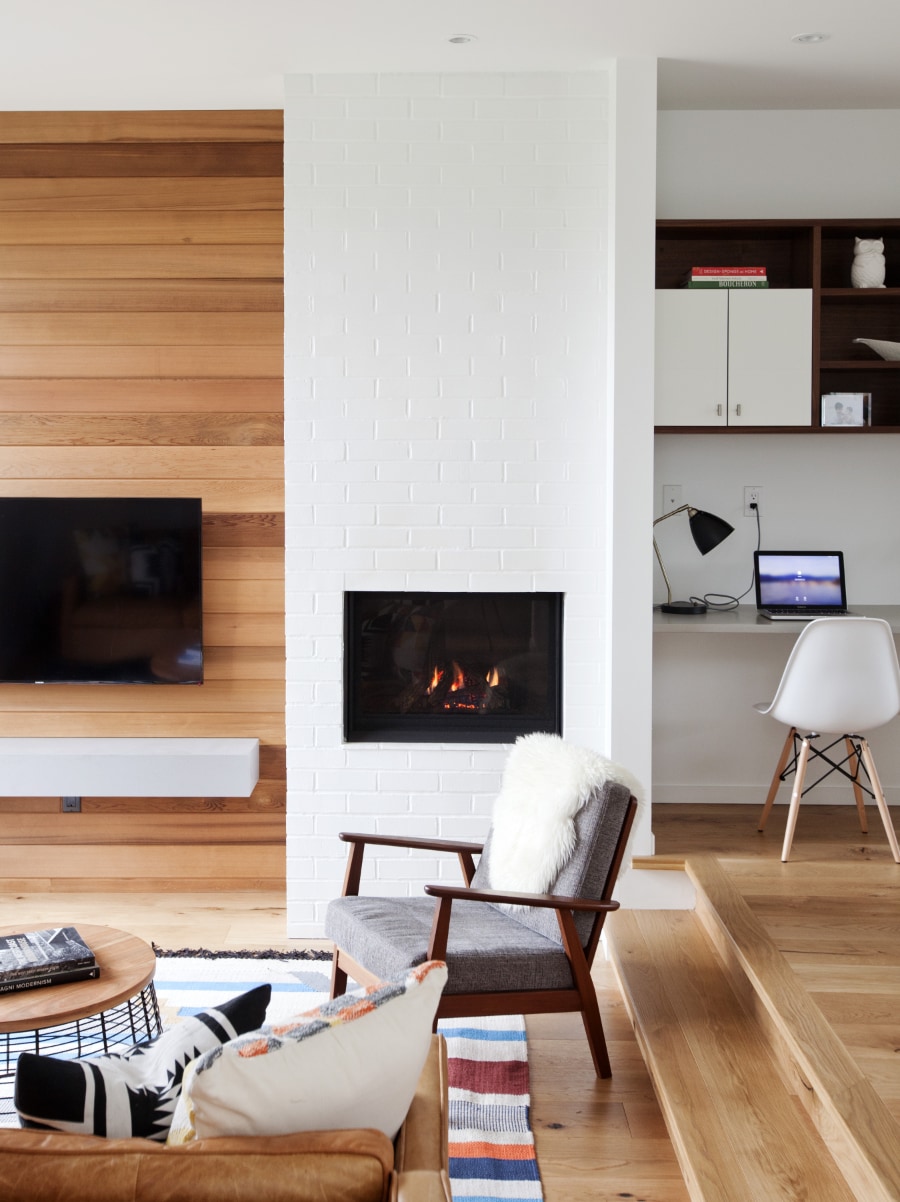 Interior image of cozy living space featuring the fireplace and hardwood elements overlooking the home office space.